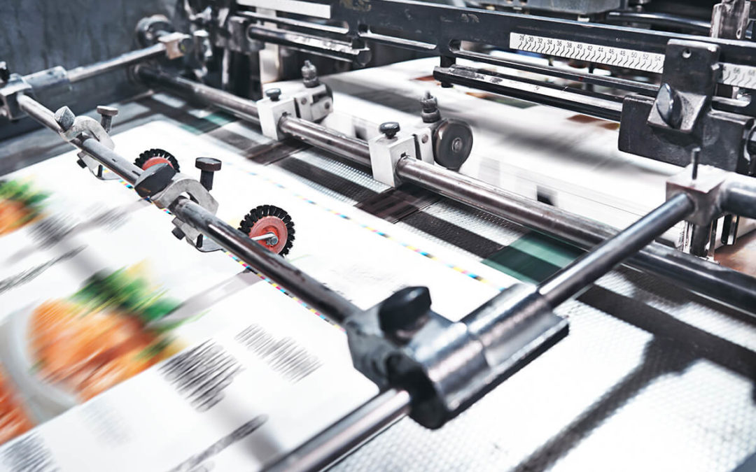 Prensa de impresión offset de alta velocidad que ejecuta una hoja de papel grande e imprime gráficos de colores vibrantes para la industria de artículos promocionales.